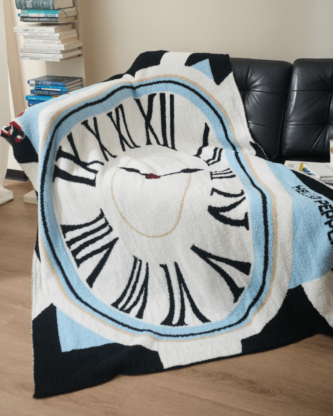 Dalí inspired throw blanket white blue border melting clock on dark sofa Hello Pepper